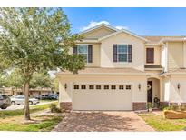 Charming townhome featuring a brick driveway and a two-car garage at 87 Delacorte Way, Oviedo, FL 32765