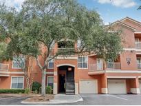 Condo building featuring covered parking and large shade tree at 8824 Villa View Cir # 204, Orlando, FL 32821