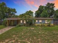 Charming single-story home with a lush front yard, mature trees, and a covered carport showcasing curb appeal at 920 Gloriosa Ave, Winter Park, FL 32789