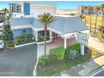 Exterior front view of Ocean Jewels Club in Daytona Beach Shores, with lush tropical landscaping and signage at 935 S Atlantic Ave # 355, Daytona Beach, FL 32118