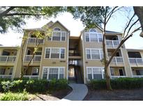 Beautiful condo building featuring balconies, mature landscaping, and a courtyard entrance at 1051 S Hiawassee Rd # 2136, Orlando, FL 32835