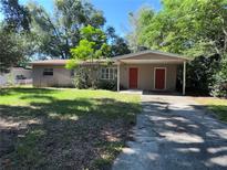 Charming single-story home with mature trees, front lawn, and covered parking area at 1420 Bethesda St, Apopka, FL 32703