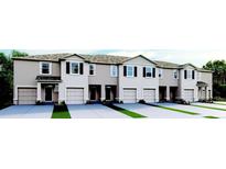 Charming townhome exterior featuring attached garages and neat landscaping at 2040 Monteverde Ave, Davenport, FL 33837