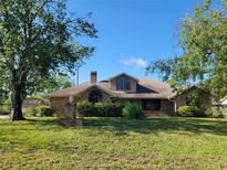 Charming brick home featuring a chimney, arched windows and an expansive well-manicured front lawn at 30 Rosedown Blvd, Debary, FL 32713
