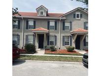 Stylish townhome featuring a tile roof, neutral paint, blue shutters, and well-maintained landscaping at 3166 Riachuelo Ln, Kissimmee, FL 34744