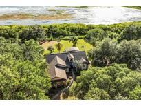 Aerial view of a house surrounded by lush greenery, showcasing its serene lakeside setting at 40137 County Road 452, Leesburg, FL 34788