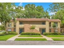 Inviting two-story condo with mature trees, manicured lawn, and visible parking at 419 Sheoah Blvd # 27, Winter Springs, FL 32708