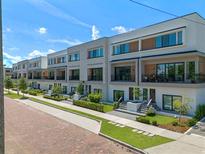 Contemporary townhomes with manicured lawns and brick-paved street offer modern living at 42 W Harding St # E, Orlando, FL 32806