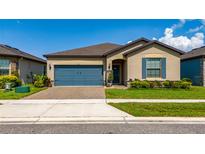 Charming single Gathering home featuring a blue garage door and shutters with a well-manicured lawn at 426 Citrus Isle Loop, Davenport, FL 33837