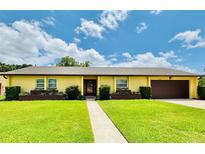 Charming single-story home with a well-manicured lawn, beautiful shrubbery and attached two car garage at 4640 Chateau Rd, Orlando, FL 32808
