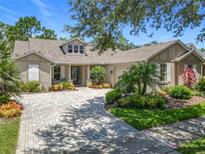 Charming single-story home with a paver driveway and lush, tropical landscaping under a bright blue sky at 600 Garden Club Dr, Deland, FL 32724