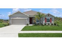 Charming single-story home with a well-manicured lawn, stone accents, and a two-car garage at 6139 Claystone Way, Mount Dora, FL 32757
