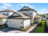 Charming two-story home featuring an attached two-car garage and walkway leading to the front door at 7745 Somersworth Dr, Kissimmee, FL 34747