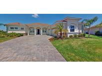 Charming single-story home featuring a tile roof, arched entryway, paver driveway, and well-maintained landscaping at 8851 Fallen Oak Dr, Davenport, FL 33896