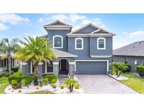 Beautiful two-story home with landscaped yard, blue exterior, and brick driveway at 1003 Nathan Ridge Rd, Clermont, FL 34715