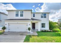 Two-story home with attached garage and landscaped yard at 372 Willet St, Haines City, FL 33844