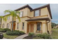 Charming two-story townhome featuring warm tones, shutters, a well-maintained front yard, and a welcoming entryway at 4031 Calabria Avenue, Davenport, FL 33897