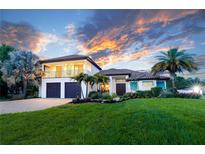 Beautiful two-story home with a well-manicured lawn, complemented by palm trees and a dramatic sunset backdrop at 7065 Branch Court, St Cloud, FL 34771