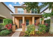 Charming two-story home with a covered front porch and well-maintained landscaping at 9389 Meadow Hunt Way, Winter Garden, FL 34787