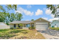 Charming single-story home with a well-manicured lawn, attached garage and neutral paint at 99 Eastridge Dr, Eustis, FL 32726