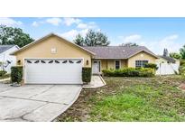Charming single-story home featuring an attached two-car garage and a well-manicured front lawn at 117 Clowson Ct, Ocoee, FL 34761