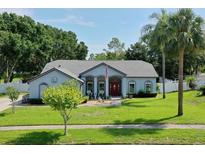 Well-maintained single-story home with a lush green lawn and mature trees at 14651 Pine Cone Trl, Clermont, FL 34711