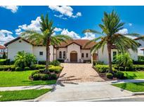 Beautiful home with a red tile roof, palm trees, and lovely landscaping at 15698 Panther Lake Dr, Winter Garden, FL 34787
