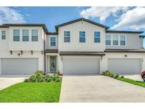 Charming townhome featuring a modern exterior, well-maintained landscaping, and a private garage at 1615 Sanibel Dr, Davenport, FL 33896