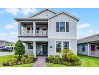 Charming two-story home with a covered porch, balcony and a beautifully landscaped front yard at 16484 Angel Fish Rd, Winter Garden, FL 34787