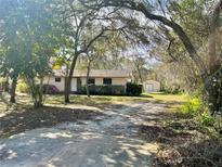 Charming home with a lush, natural front yard and an outbuilding, set back from the road at 285 W 2Nd St, Chuluota, FL 32766