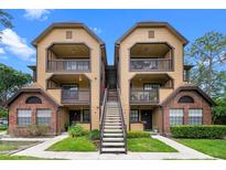 Inviting condo complex featuring multi-story buildings, beautiful landscaping, and exterior stairs at 380 Lake Ontario Ct # 201, Altamonte Springs, FL 32701