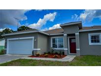 Beautiful, single-story home featuring well-kept landscaping, a two-car garage, and a stylish red front door at 475 Marion Oaks Mnr, Ocala, FL 34473