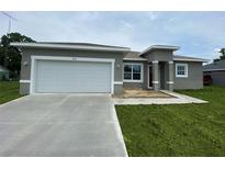 Charming single-story home with a two-car garage, concrete driveway, and freshly landscaped lawn at 475 Marion Oaks Mnr, Ocala, FL 34473