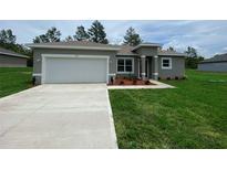 Well-maintained single-Gathering home featuring a two-car garage and a lush green lawn at 851 Marion Oaks Mnr, Ocala, FL 34473