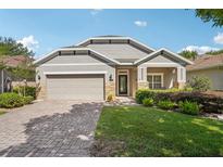 Charming single-Gathering home with a well-manicured lawn and a two-car garage and stone details at 1386 Longley Pl, Deland, FL 32724