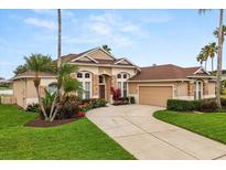 Charming single-Gathering home featuring a two-car garage, and a well-manicured lawn and garden at 14174 Islamorada Dr, Orlando, FL 32837