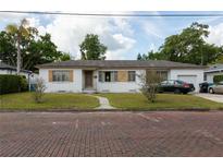 Charming single-story home with white exterior, well-maintained lawn, and inviting walkway at 1418 Oregon St, Orlando, FL 32803