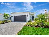 Beautiful one-story home showcasing a well-manicured lawn and a neutral-toned exterior at 1461 Santorini Way, Tavares, FL 32778