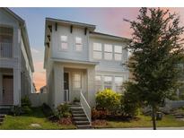 Charming two-story home with a well-maintained lawn and inviting front porch with white stairs and railing at 15408 Lebeau Loop, Winter Garden, FL 34787