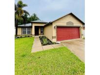 Charming single-story home featuring a well-manicured lawn and a striking red garage door at 16116 Corner Lake Dr, Orlando, FL 32820