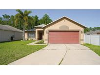 Charming single-story home with a well-manicured lawn, palm tree, and a red two-car garage at 16116 Corner Lake Dr, Orlando, FL 32820
