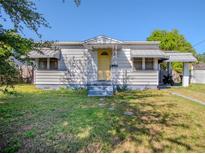 Charming single-story home featuring a covered porch and yellow front door at 1615 Crestwood Dr, Orlando, FL 32804