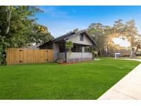 Charming home featuring a well-manicured lawn, fenced yard, and inviting front porch at 205 W Princeton St, Orlando, FL 32804