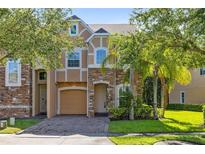 Charming two-story home featuring stone accents, a paved driveway, and lush landscaping at 2153 Cypress Villas Dr, Orlando, FL 32825