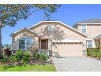 Charming single-Gathering home showcasing a manicured lawn and a two-car garage at 23820 Sardinia Dr, Sorrento, FL 32776
