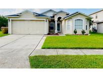 Charming one-story home featuring an attached two-car garage and well-manicured lawn at 2511 Brookstone Dr, Kissimmee, FL 34744