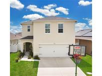 Two-story home with neutral siding, an attached garage and basketball hoop in the front yard at 2834 Common Crane Ct, St Cloud, FL 34773