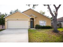 Charming single-story home featuring a two-car garage, landscaped yard and a neutral-toned exterior at 30101 Pga Dr, Sorrento, FL 32776