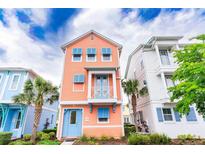 Charming peach-colored two-story home featuring blue shutters and accents with a small, decorative balcony at 3062 Pirate Way, Kissimmee, FL 34747
