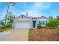 Charming single-story home with a two-car garage, landscaped yard, and welcoming entrance at 3479 Courtland Blvd, Deltona, FL 32738
